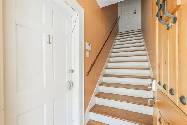 a view of staircase with railing and white walls