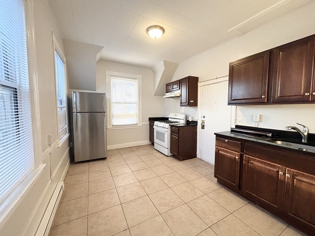 92 Main Street, Unit 1 Malden, MA 02148 - Photo 3 of 7 a kitchen with stainless steel appliances granite countertop a stove a refrigerator and a sink