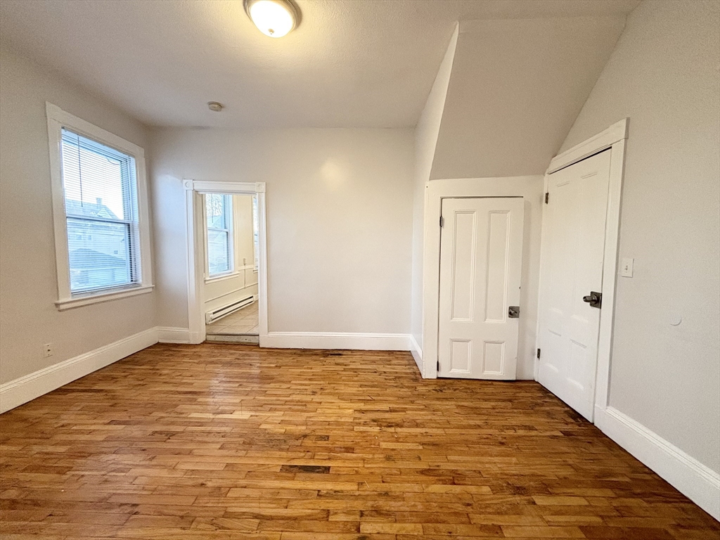 92 Main Street, Unit 1 Malden, MA 02148 - Photo 5 of 7 a view of an empty room with window and wooden floor