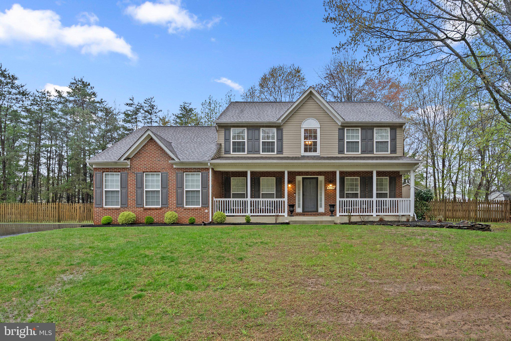 a front view of a house with a yard and trees