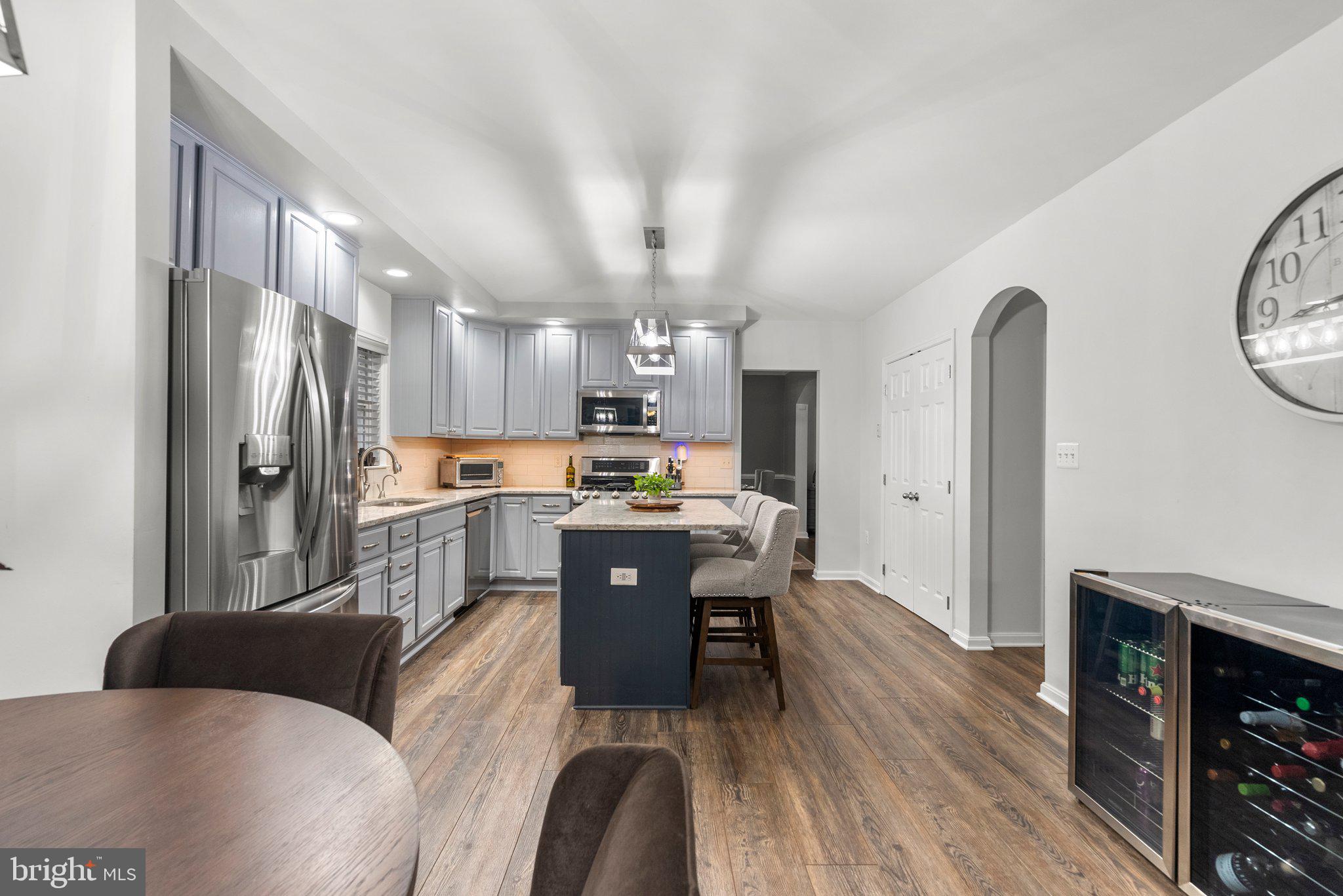 6355 Grant Chapman Drive La Plata, MD 20646 - Photo 22 of 57 a kitchen with stainless steel appliances granite countertop a refrigerator a stove top oven a sink dishwasher and white cabinets with wooden floor