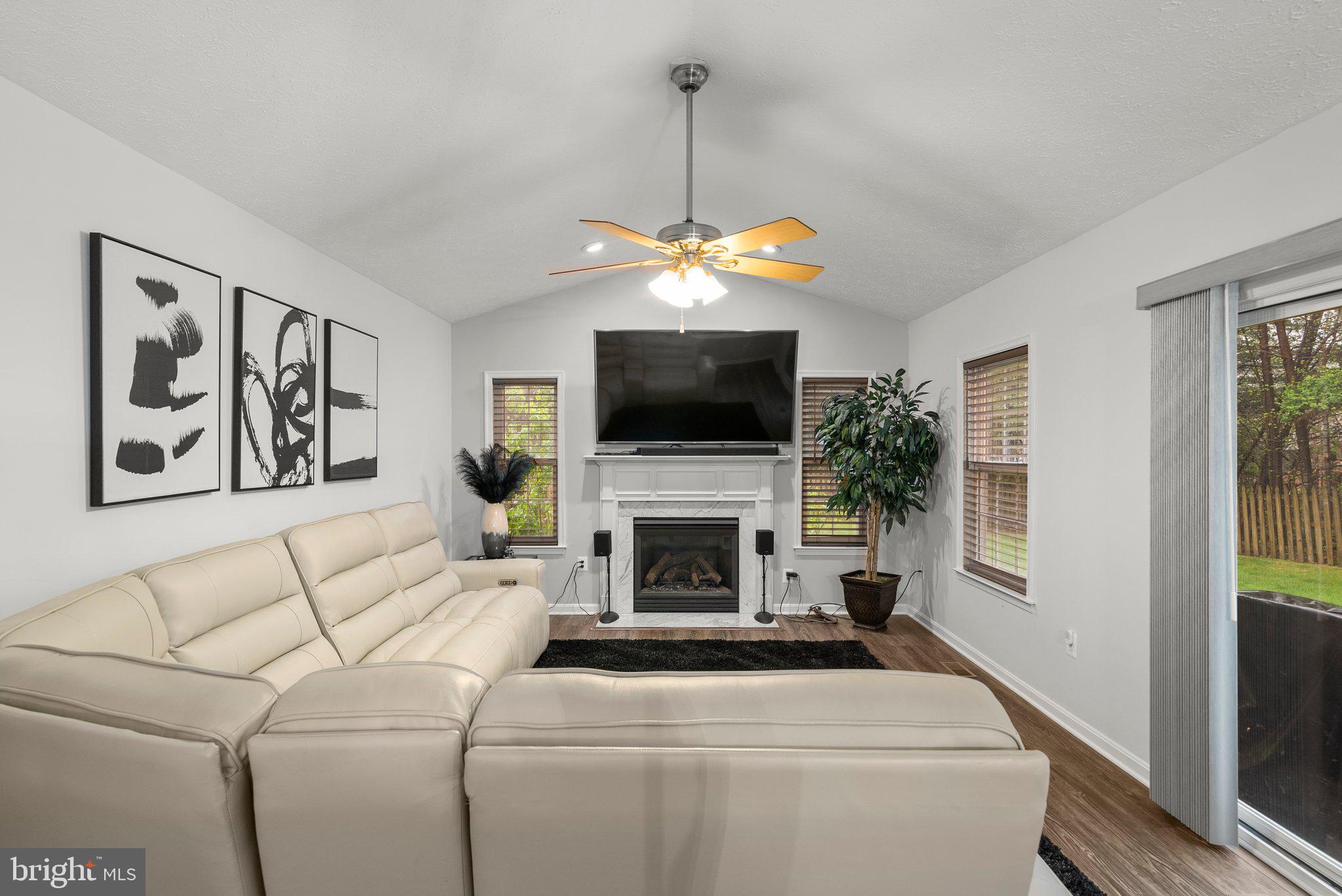 6355 Grant Chapman Drive La Plata, MD 20646 - Photo 23 of 57 a living room with furniture a flat screen tv and a fireplace