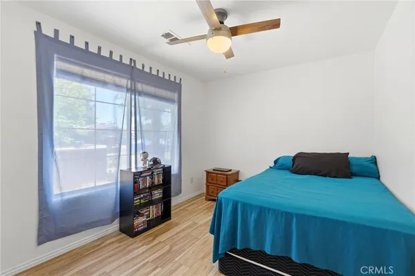 a bedroom with a bed and a wooden floor