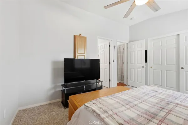 a bedroom with a bed and a flat screen tv