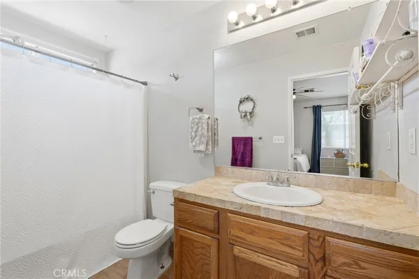 a bathroom with a sink toilet vanity and shower