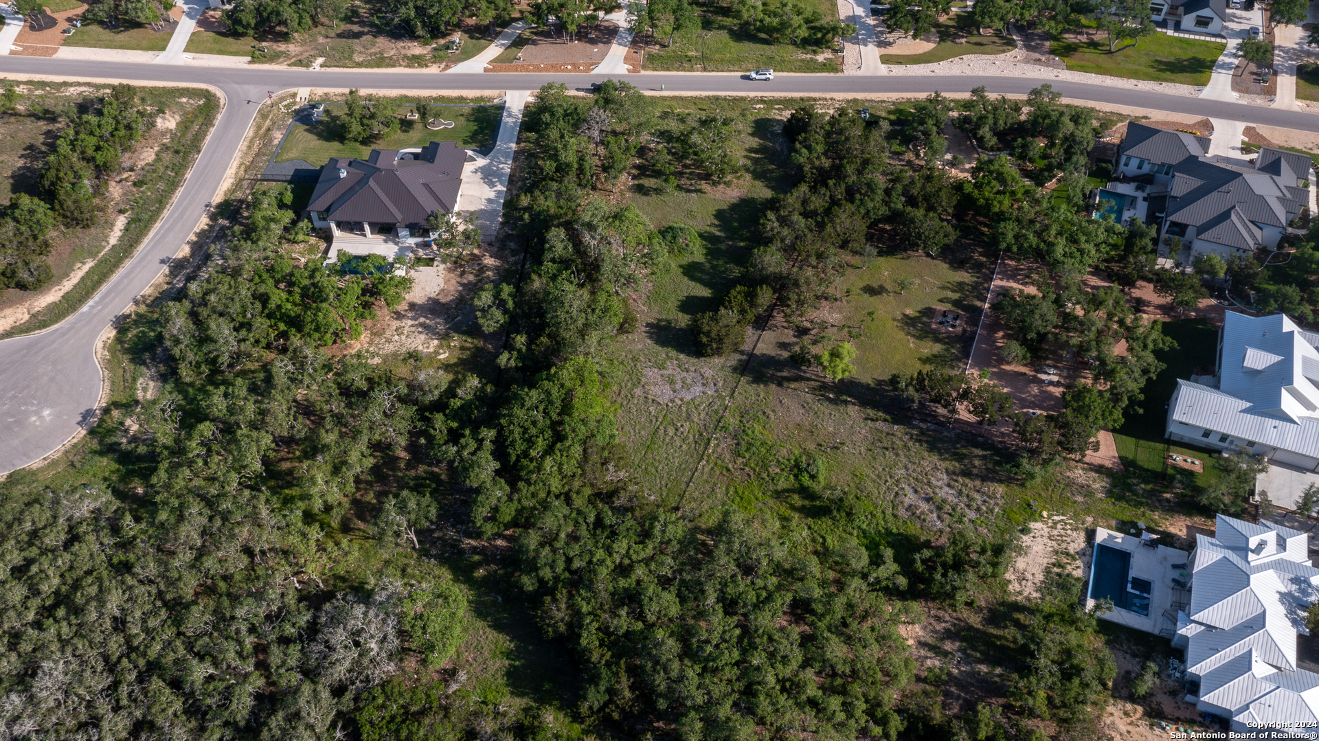 739 Maximino Ridge Road Bulverde, TX 78163 - Photo 10 of 36 a view of a garden with a building and trees in the background