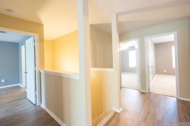 a view of a hallway with wooden floor