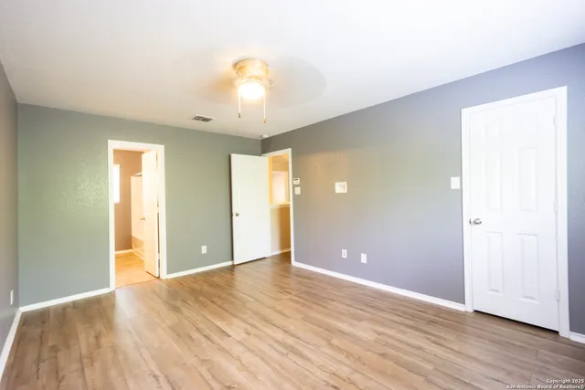 an empty room with wooden floor and windows
