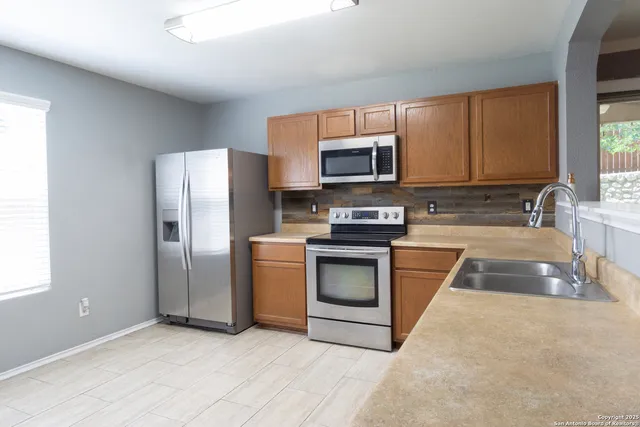 a kitchen with granite countertop a refrigerator stove and microwave