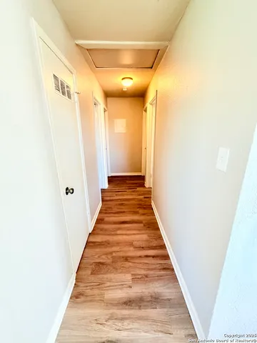 a view of a hallway with wooden floor