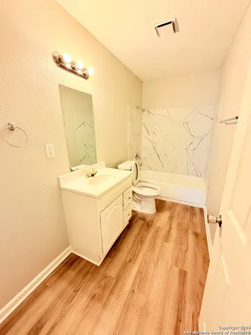 a bathroom with a white tub shower vanity and a sink