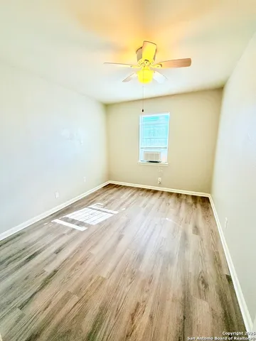 a view of empty room with wooden floor