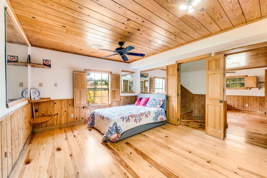 539 North Duncanville Road Cedar Hill, TX 75104 - Photo 22 of 36 a spacious bedroom with a large bed a chandelier and windows