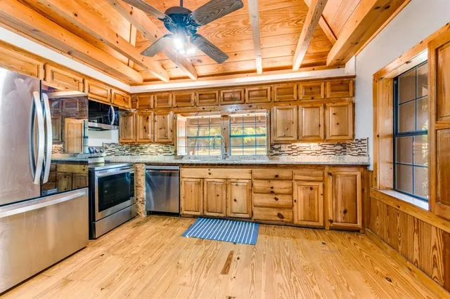 a kitchen with stainless steel appliances granite countertop a stove a sink and a refrigerator