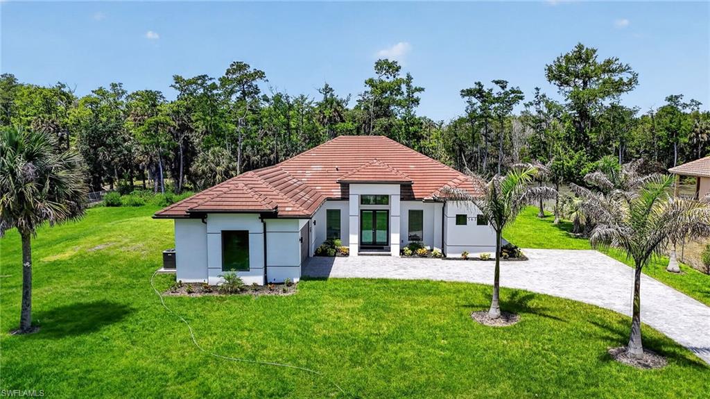 563 15th Street Northwest Naples, FL 34120 - Photo 2 of 22 a front view of a house with a garden