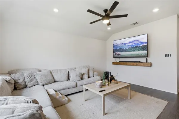 a living room with furniture and a view of kitchen