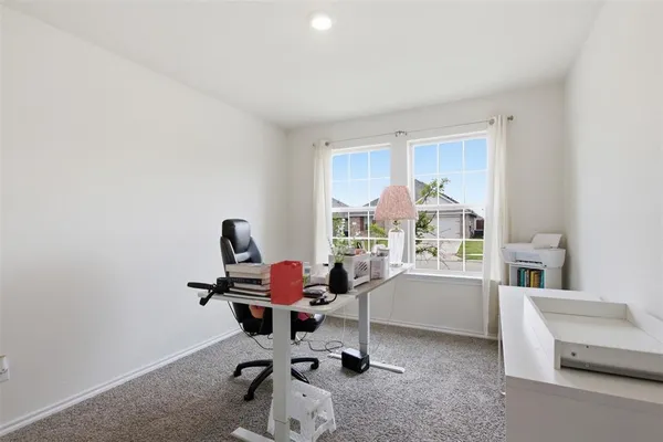 a view of a workspace with furniture and a window