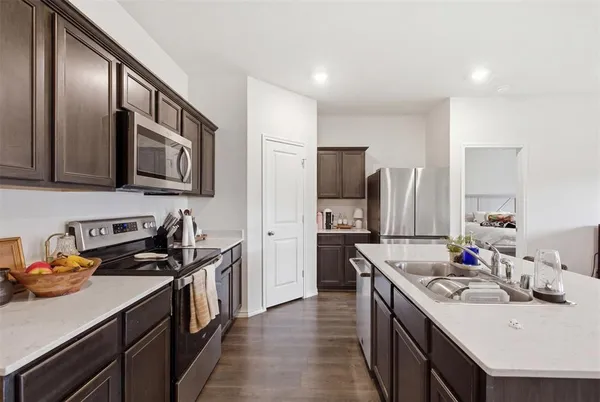 a kitchen with a sink stove top oven and refrigerator