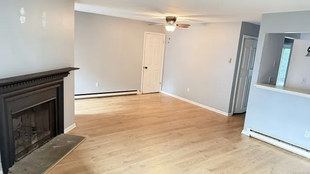 an empty room with wooden floor and a fireplace