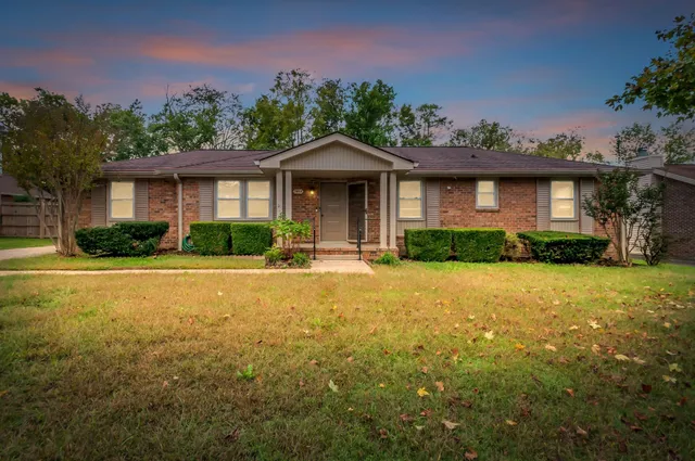 a front view of a house with yard and green space
