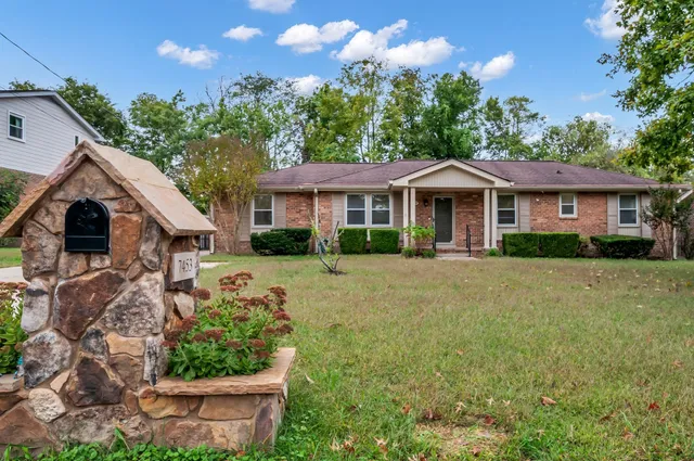 a front view of a house with a garden