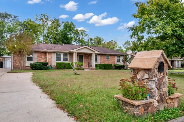 a front view of a house with a yard and outdoor seating