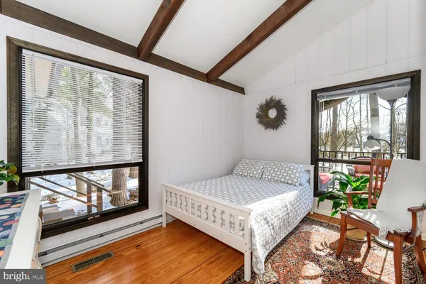 a bedroom with a bed and wooden floor