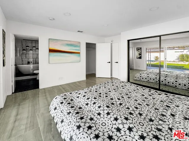 a bedroom with a bed and a mirror