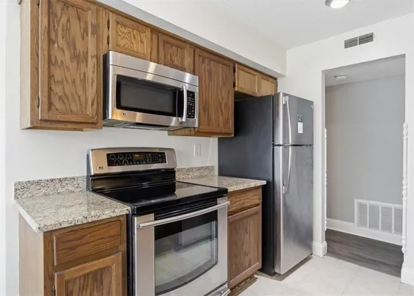 a kitchen with stainless steel appliances granite countertop a stove microwave and refrigerator