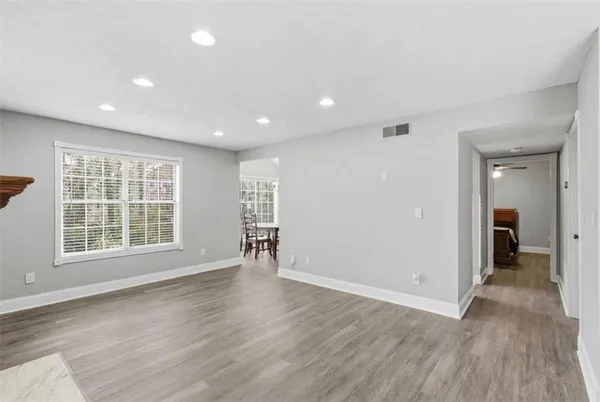 an empty room with wooden floor and windows