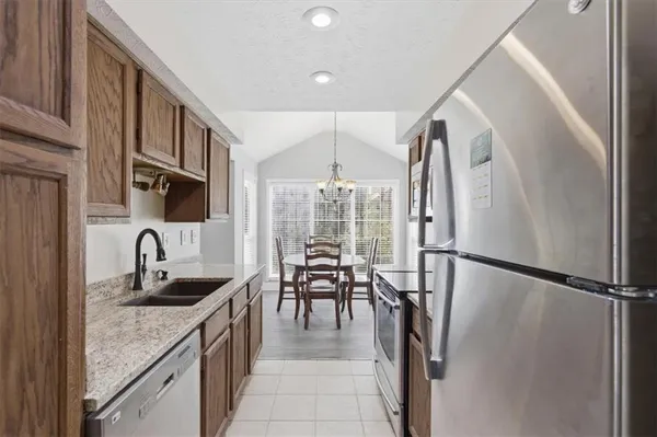 a kitchen with sink a refrigerator and chairs