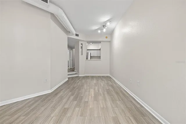 a view of an empty room with wooden floor