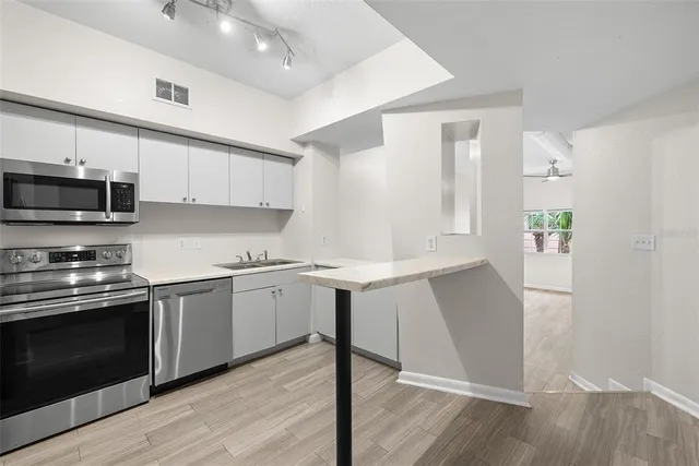 a kitchen with stainless steel appliances granite countertop a refrigerator sink and stove