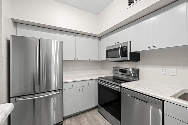 a kitchen with appliances a sink and cabinets