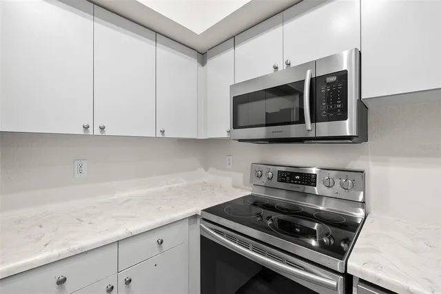 a kitchen with stainless steel appliances a refrigerator sink and microwave