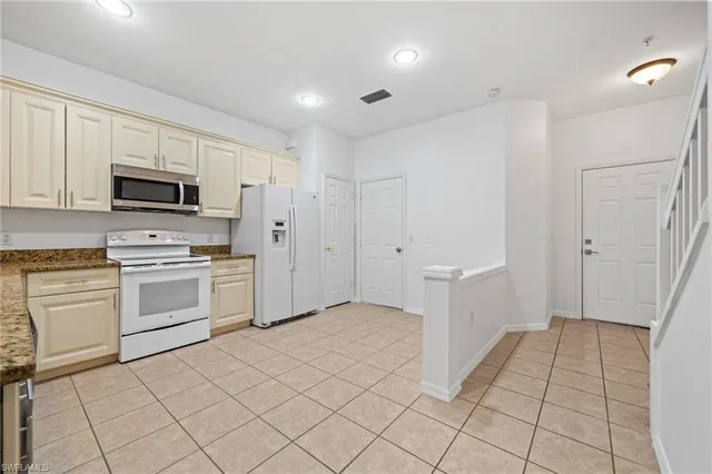 a kitchen with white cabinets and white appliances