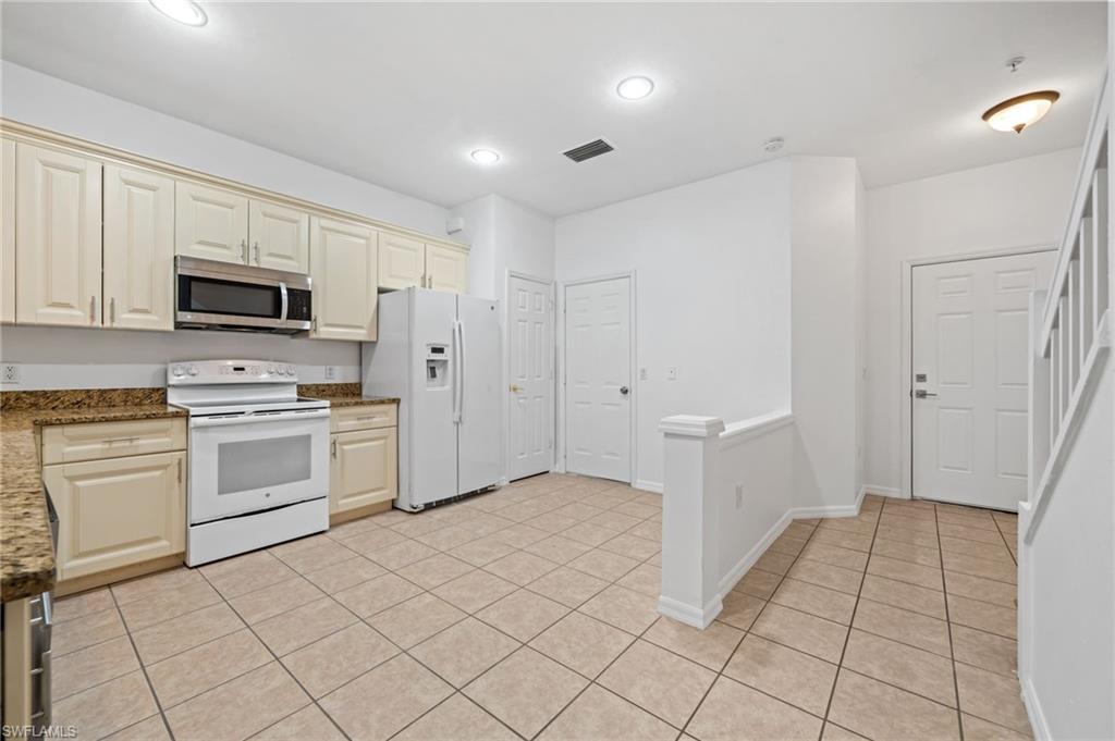 880 Hampton Circle, Unit 160 Naples, FL 34105 - Photo 11 of 32 a kitchen with white cabinets and white appliances