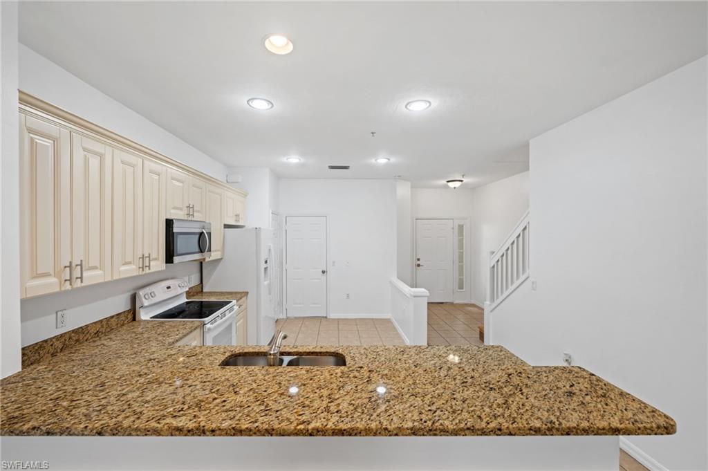 880 Hampton Circle, Unit 160 Naples, FL 34105 - Photo 12 of 32 a living room with a couch and a rug