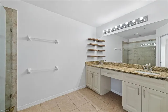 a bathroom with a granite countertop sink a mirror and a shower