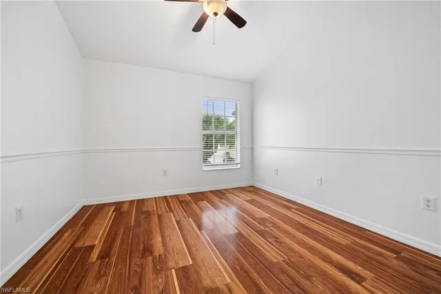 a view of a room with wooden floor closet and a ceiling fan