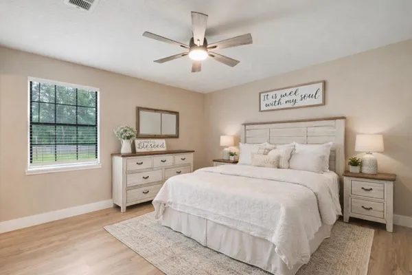 a bedroom with a bed a window and a dresser