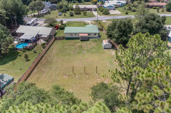 an aerial view of a house with a yard and trees