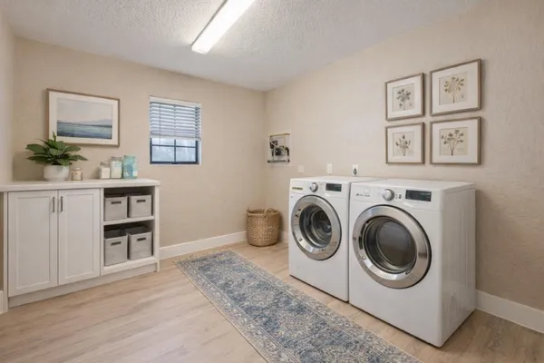 a utility room with cabinets dryer and washer