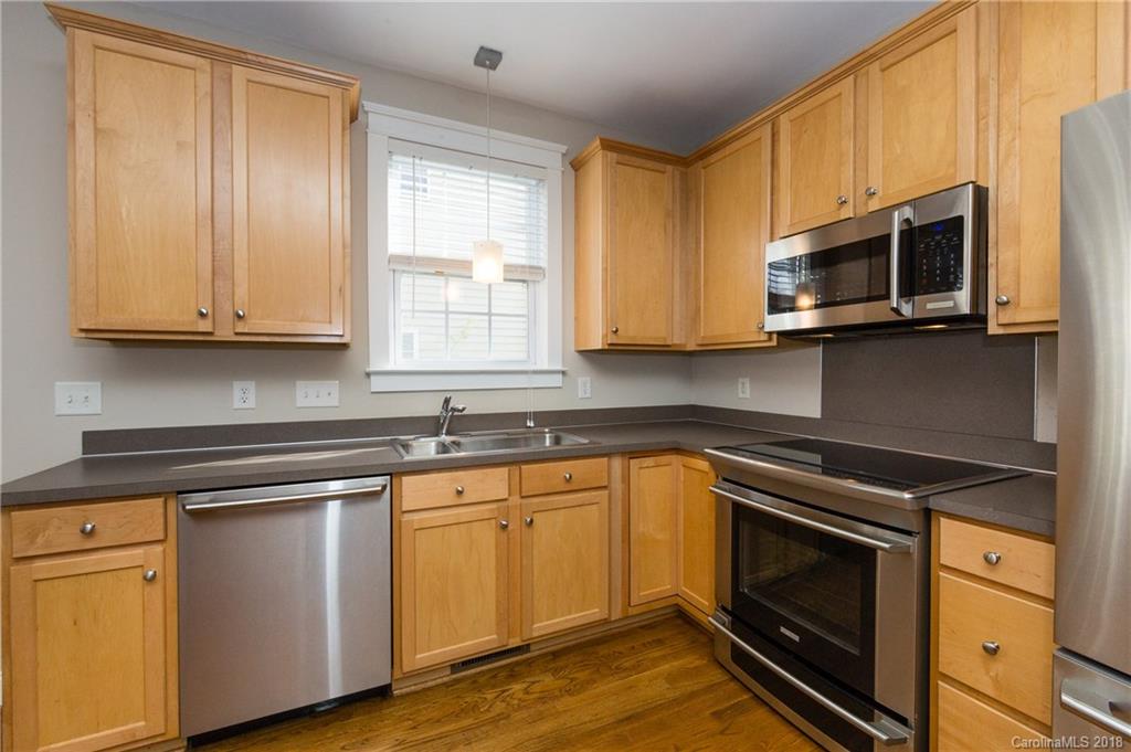 17530 Invermere Avenue Huntersville, NC 28078 - Photo 16 of 36 a kitchen with granite countertop wooden cabinets stainless steel appliances and a window