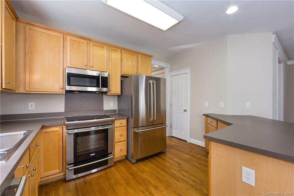 17530 Invermere Avenue Huntersville, NC 28078 - Photo 17 of 36 a kitchen with wooden cabinets and stainless steel appliances