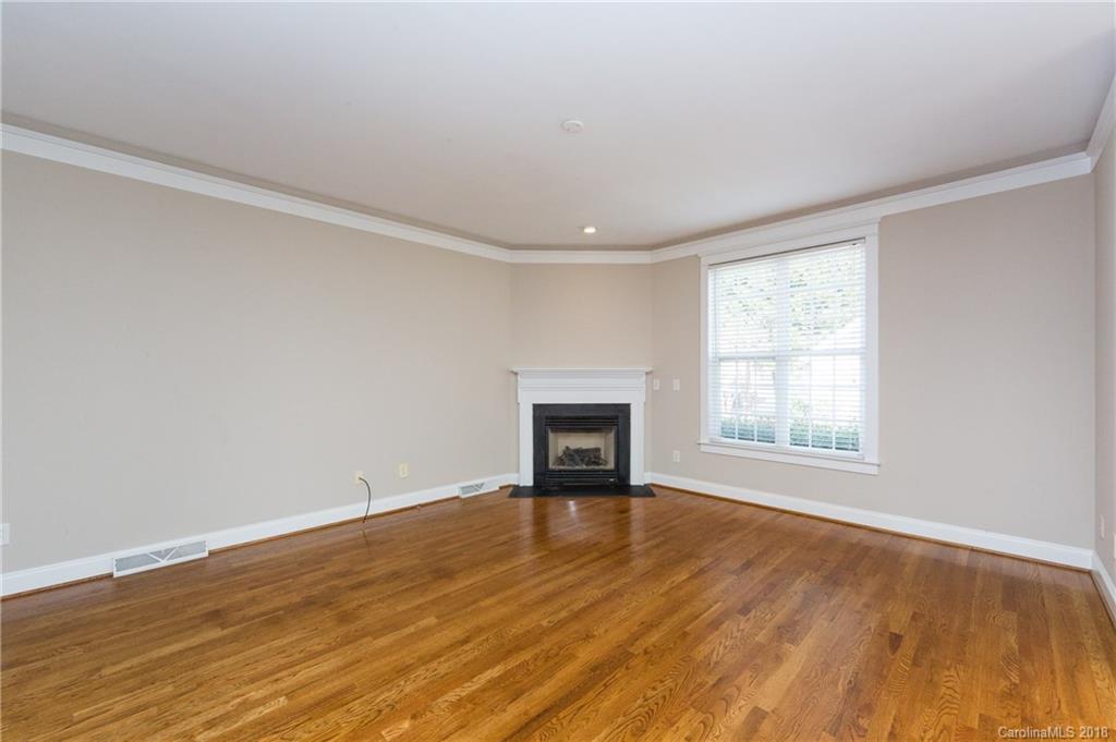 17530 Invermere Avenue Huntersville, NC 28078 - Photo 9 of 36 an empty room with wooden floor and fireplace