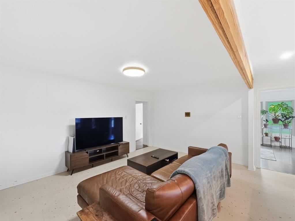2137 Lenamon Street Waco, TX 76710 - Photo 13 of 29 Living area with light-colored flooring, white walls, and a prominent wood beam accent