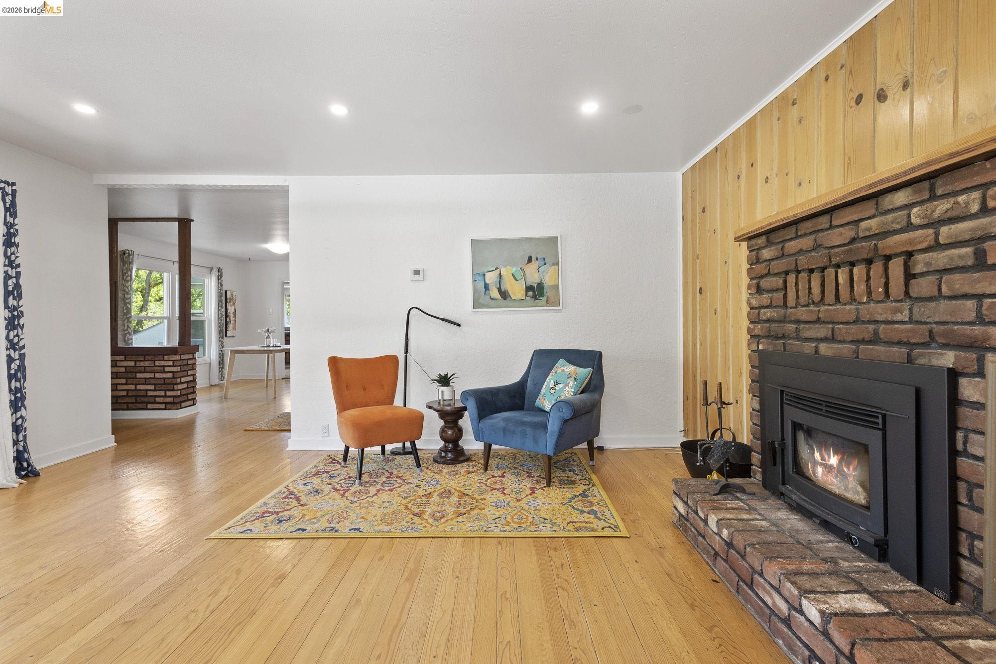 18363 Yosemite Road Tuolumne, CA 95379 - Photo 8 of 34 Spacious living area featuring light wood-finish flooring, recessed lighting, and a brick fireplace with a wood mantle