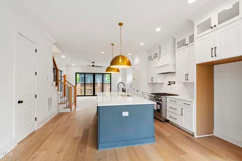 a view of an empty room with wooden floor fireplace and a window