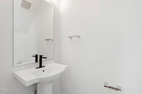 an empty room with wooden floor chandelier fan and windows